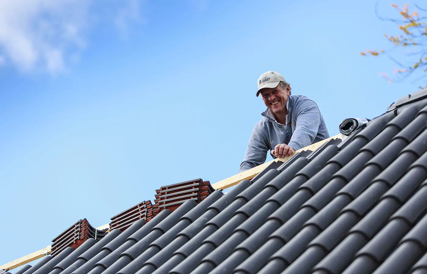 Herr Rieger auf einem Dach beim Dachdecken